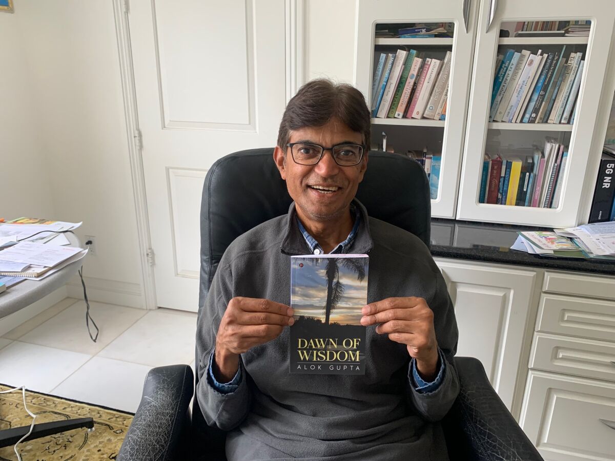 Encinitas resident Alok Gupta displays the cover of his recently published poetry book, “Dawn of Wisdom.”