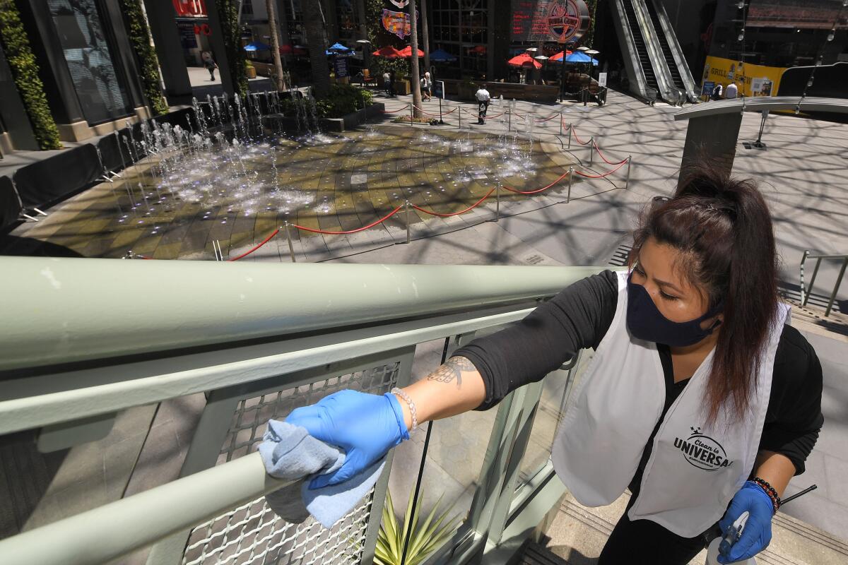 Andrea Castaneda cleans railings June 11 at Universal CityWalk near Universal City.