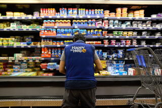 A worker stocks a shelf in a grocery aisle at a Walmart store. Photographer: Brian Kaiser/Bloomberg