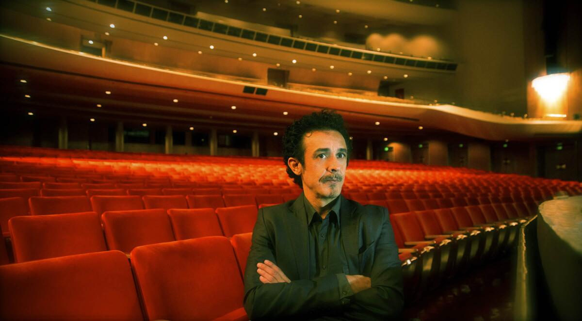 Spanish composer Juan Jose Colomer stands in a concert hall.