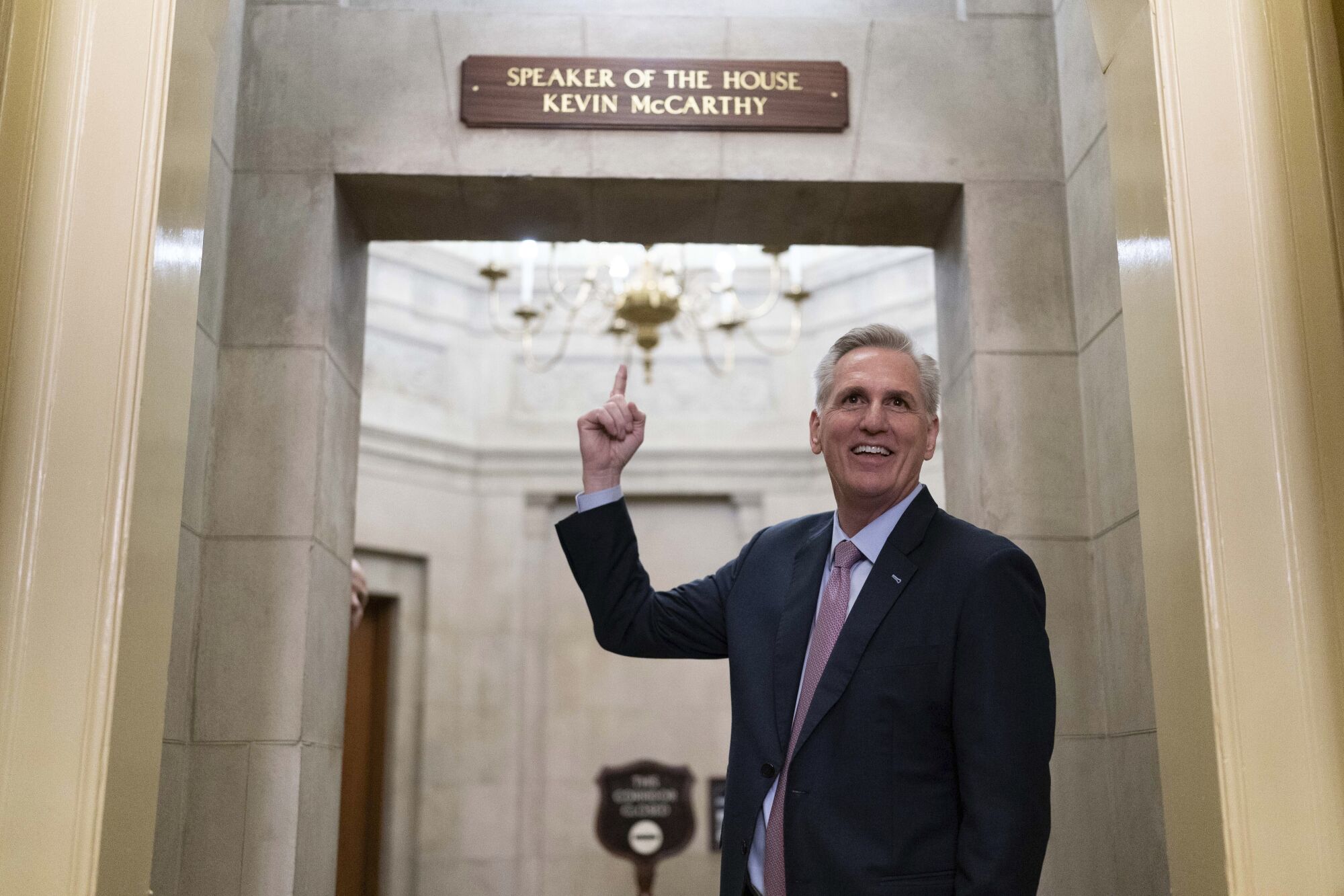 House Speaker Kevin McCarthy points to the newly installed nameplate at his office 