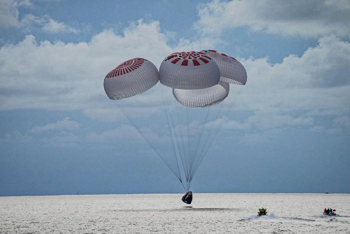 En esta imagen facilitada por SpaceX, una cápsula con cuatro personas desciende en paracaídas 