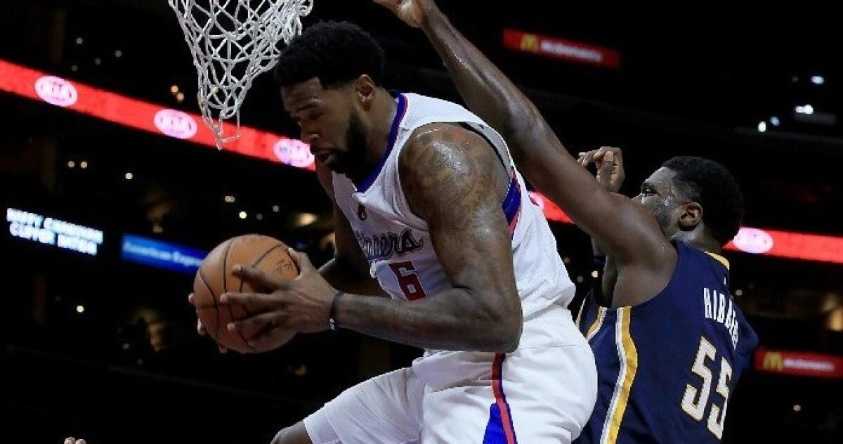 DeAndre Jordan swallows up a rebound in front of Indiana center Roy Hibbert during the Clippers' 102-100 win Wednesday over the Pacers.