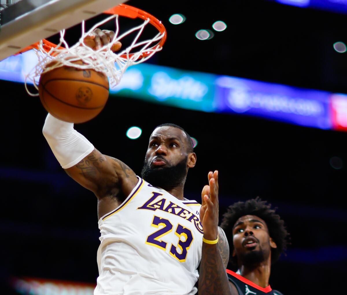 Lakers star LeBron James dunks over Houston Rockets forward Tari Eason on Sunday night.