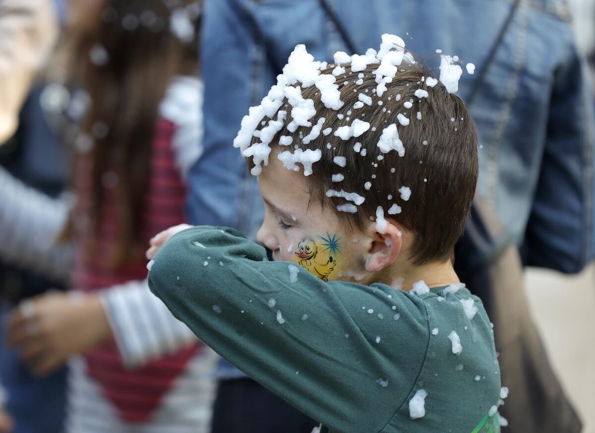 Joey Cabello wipes his face after a brief snow flurry in Santa's Village during the Sawdust Winter Fantasy festival.