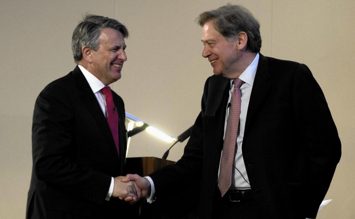 Ben van Beurden, CEO of petroleum giant Royal Dutch Shell, left, shakes hands with the chairman of BG Group, Andrew Gould, in a news conference announcing a $70-billion deal that could inspire copycat deals in the oil and gas industry as companies struggle to adjust to months of collapsing crude prices.