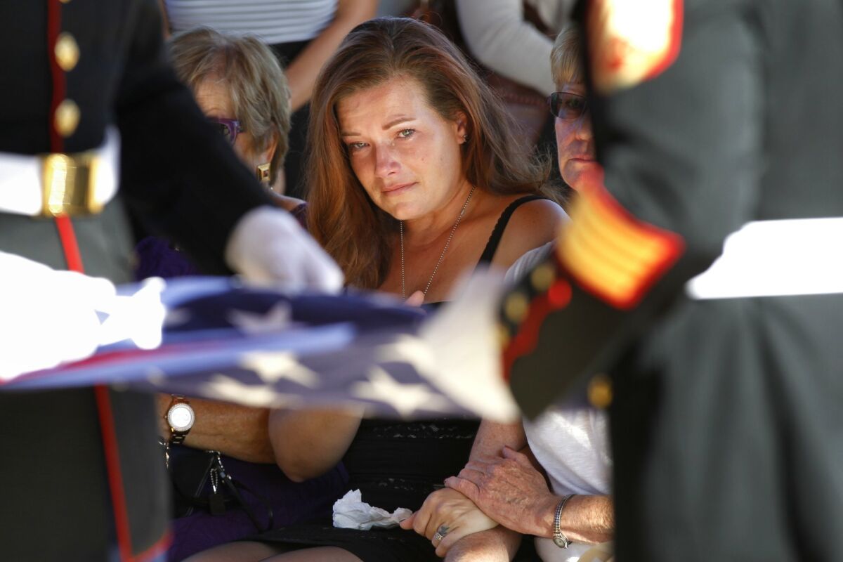 Tami Sears watches as Marines fold a flag during a memorial service for her husband, Marine Jeremy Sears at Miramar National Cemetery. — K.C. Alfred / UT San Diego