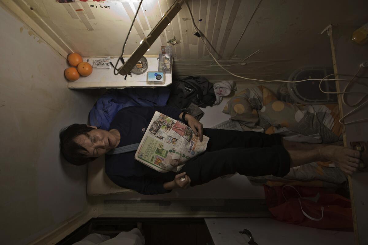 A resident who gave only his surname, Yeung, takes rest in his tiny flat in Hong Kong. In wealthy Hong Kong, there's a dark side to a housing boom, with hundreds of thousands of people forced to live in partitioned shoebox apartments known as "coffin homes."