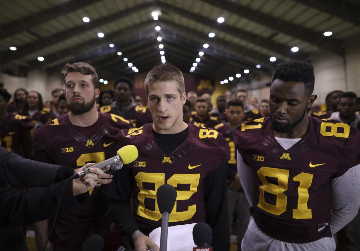 Minnesota wide receiver Drew Wolitarsky flanked by quarterback Mitch Leidner, left, and tight end Duke Anyanwu, with the rest of the team standing behind them, read a statement on behalf of the players on Dec. 15.