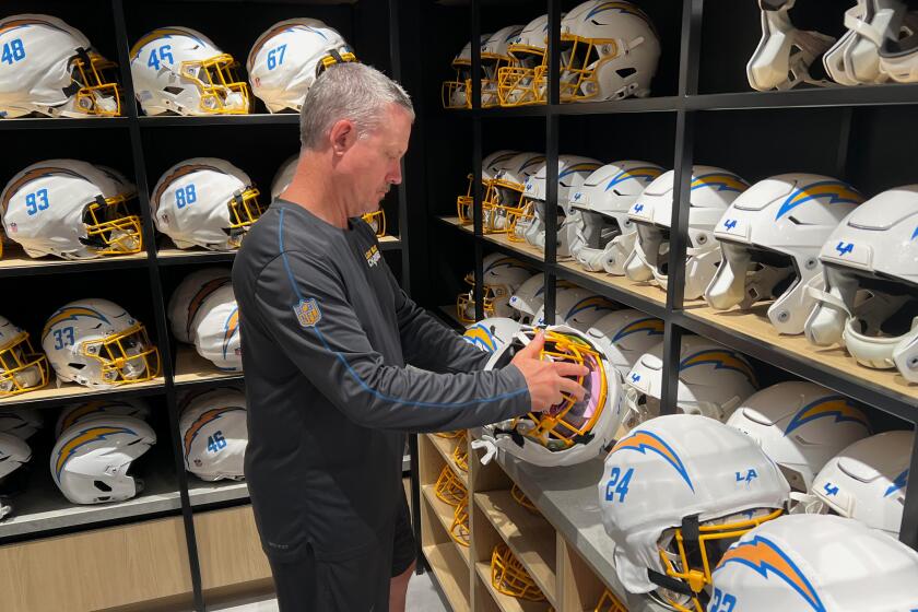 Chris Smith, director of equipment operations for the Chargers, inspects helmets.