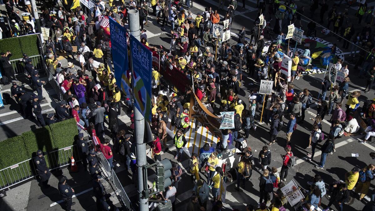 Hundreds of protesters push their way toward the Moscone Center, which is hosting the Global Climate Action Summit this week in San Francisco.