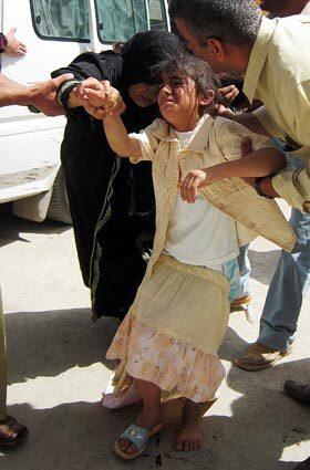 A mother and her daughter are evacuated from the site of the car bombing. The street on which the bomb was placed is surrounded by government buildings and is lined with shops and restaurants, among them a famous eatery called Salal.