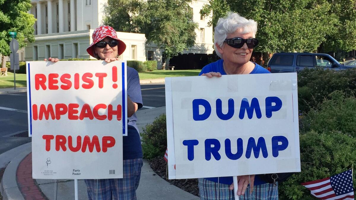 Marilyn Irish, 71, left. and Londa Lehman, 71, stand near the Plumas County Courthouse in Quincy every Friday afternoon to protest President Trump. Plumas County voted for Trump.