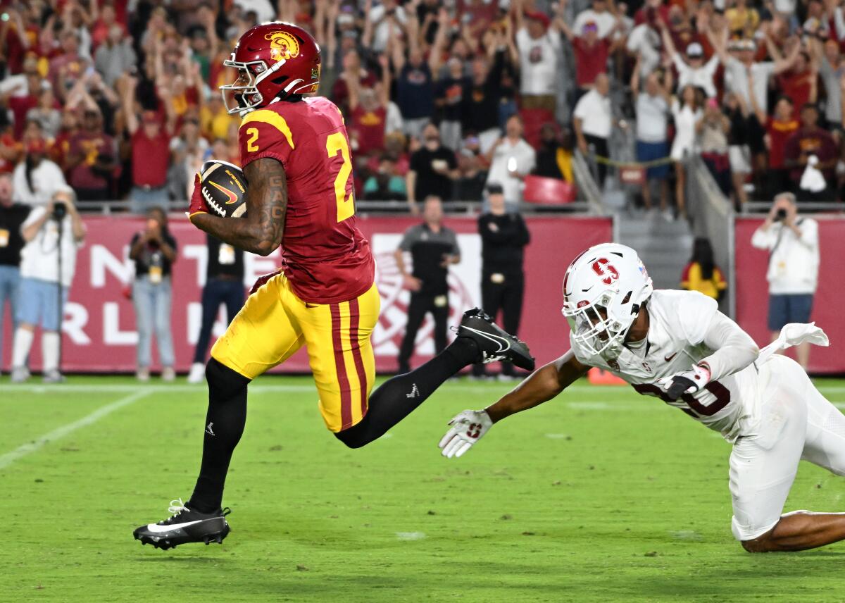 USC receiver Brenden Rice hauls in a 75-yard touchdown pass in front of Stanford cornerback Jaden Slocum 