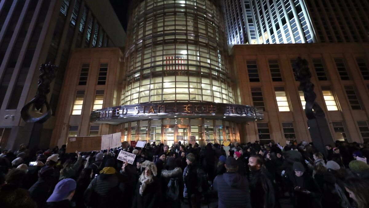 Demonstrators gather outside U.S. District Court in Brooklyn, N.Y., where a judge issued an emergency stay for those detained at airports under President Trump's executive action.