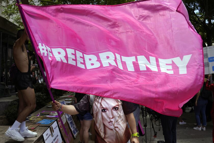 A Britney Spears supporter waves a "Free Britney" flag outside a court hearing concerning the pop singer's conservatorship at the Stanley Mosk Courthouse, Wednesday, June 23, 2021, in Los Angeles. (AP Photo/Chris Pizzello)
