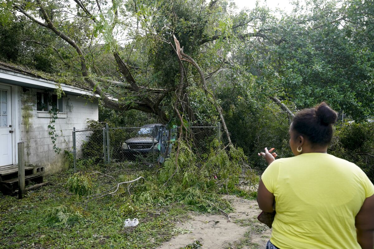 Seleka Souls looks over a neighbor's home that was damaged by Hurricane Sally on Friday in Pensacola, Fla.