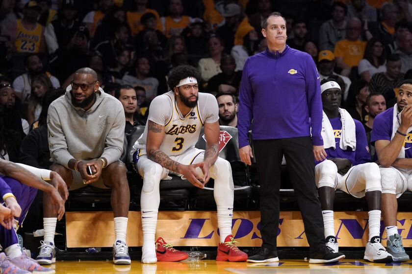 Los Angeles Lakers forward LeBron James, left, sits on the Bech next to forward Anthony Davis as head coach Frank Vogel stands by during the second half of an NBA basketball game against the Denver Nuggets Sunday, April 3, 2022, in Los Angeles. (AP Photo/Mark J. Terrill)