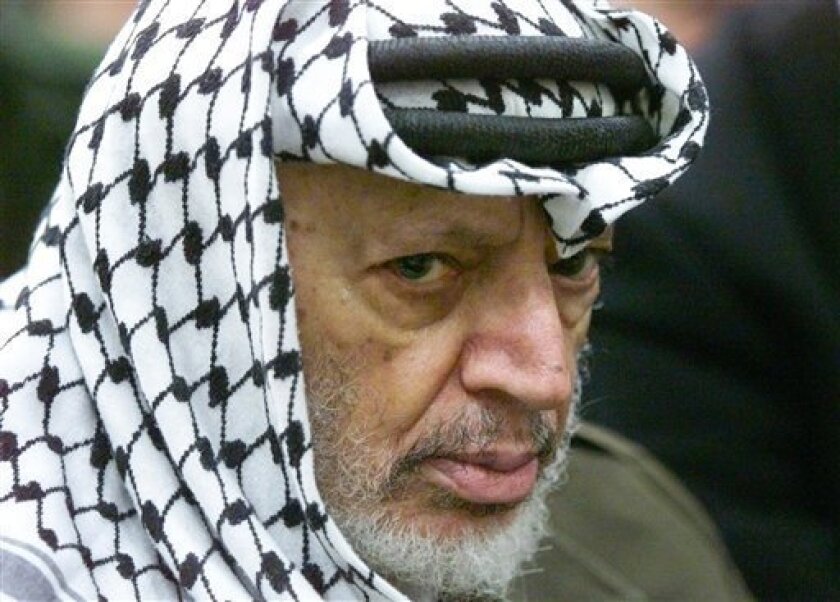 FILE - In this May 31, 2002 file photo photo Palestinian leader Yasser Arafat pauses during the weekly Muslim Friday prayers in his headquarters in the West Bank city of Ramallah. Yasser Arafat's body may be exhumed to allow for more testing of the causes of his death, the Palestinian president said Wednesday, July 4, 2012, after a Swiss lab said it found elevated levels of a radioactive isotope in belongings the Palestinian leader is said to have used in his final days. (AP Photo/Lefteris Pitarakis, File)