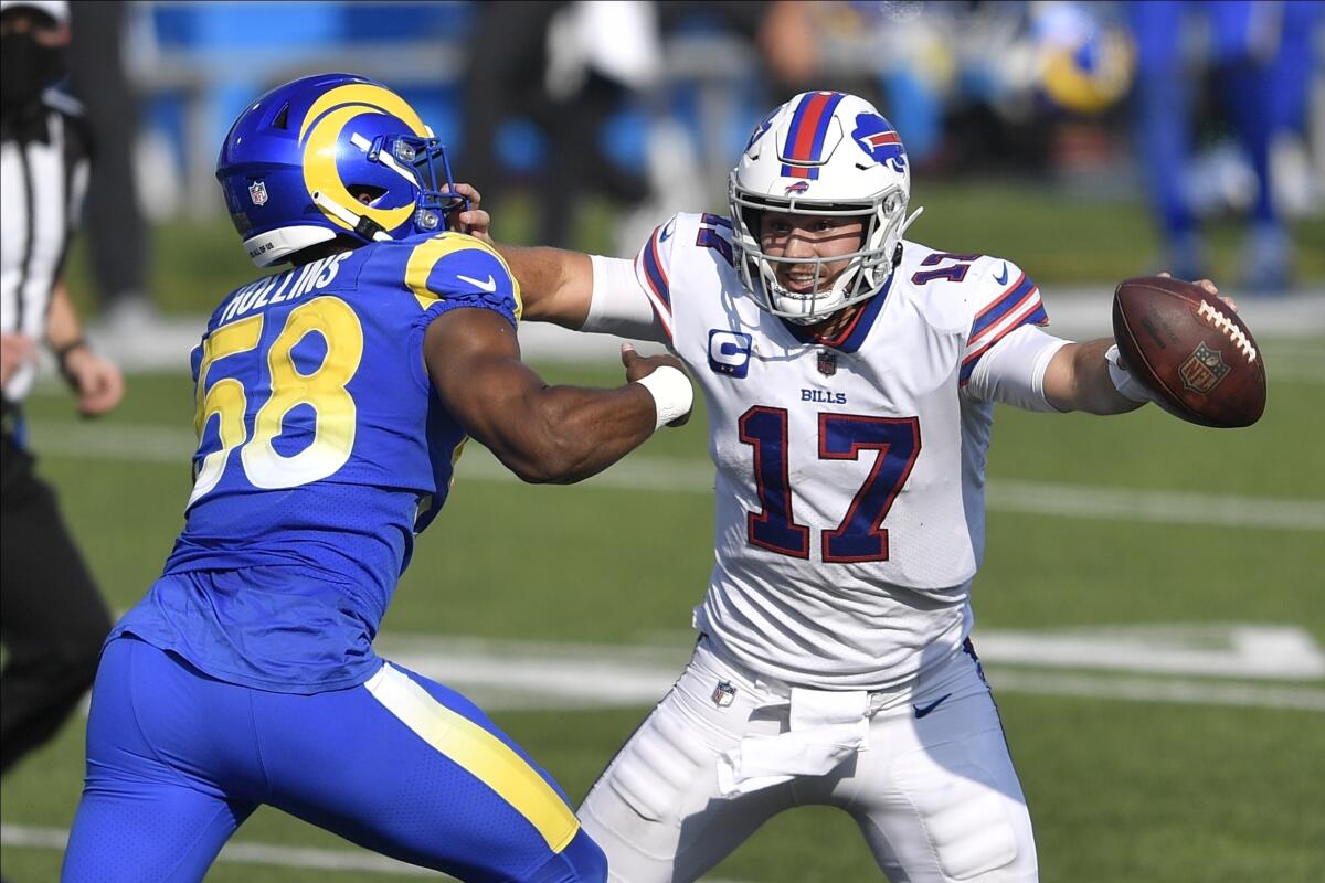 Buffalo Bills quarterback Josh Allen stiff-arms Rams linebacker Justin Hollins.