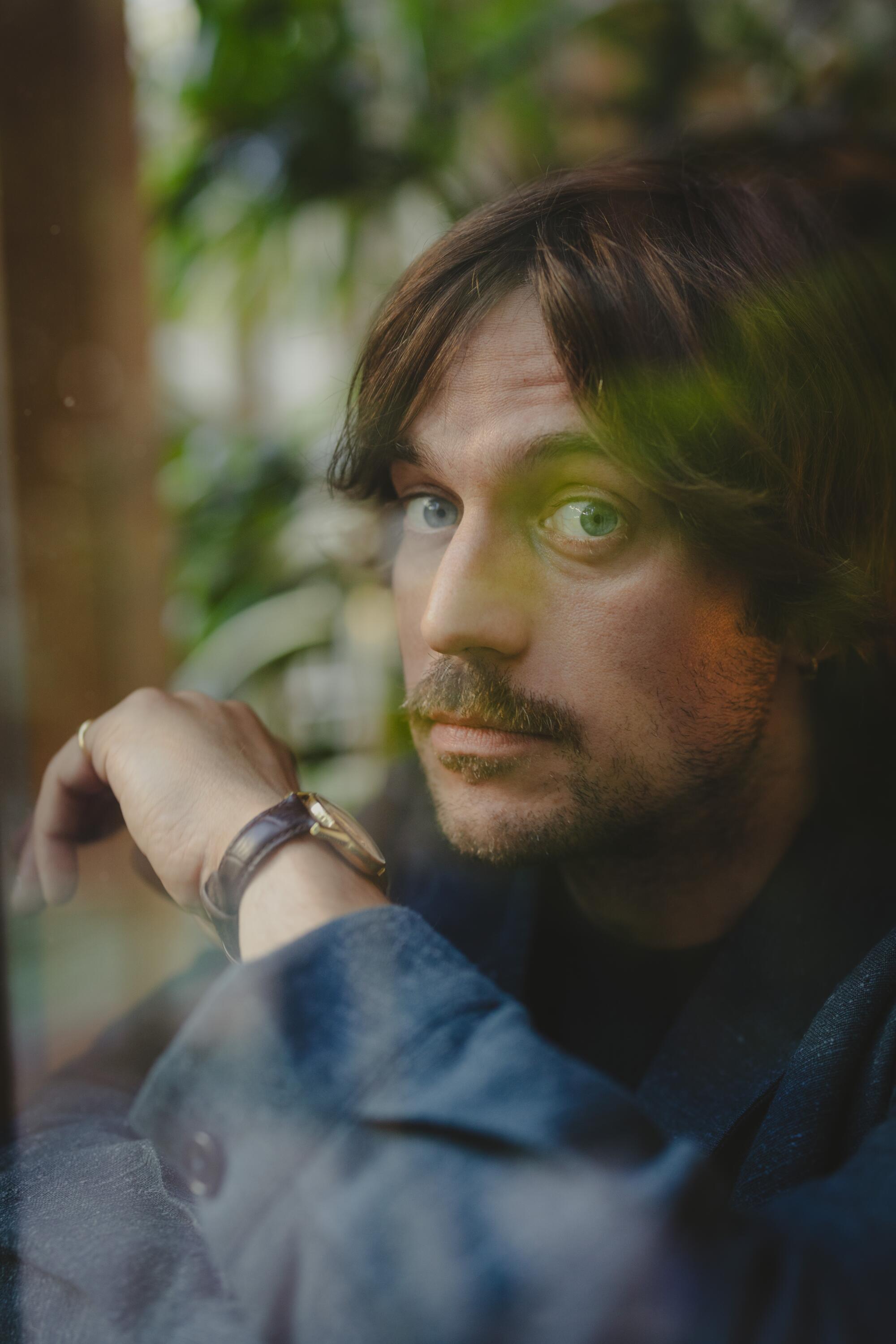 "Emily in Paris" star Lucas Bravo through a window.