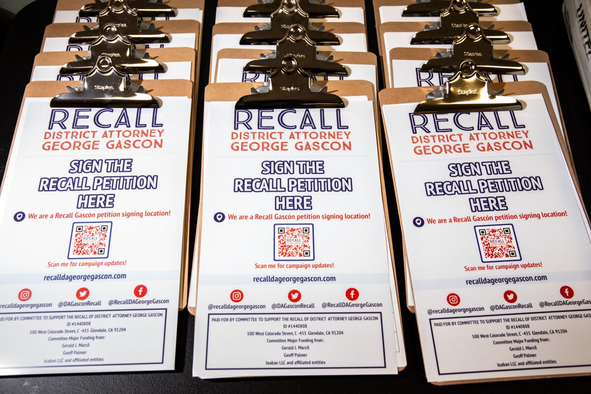 Clipboards hold petiton forms that read "Recall District Attorney George Gascón"