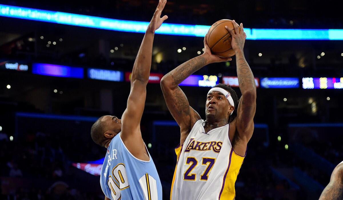 Lakers center Jordan Hill elevates for a shot over Nuggets power forward Darrell Arthur in the first half.