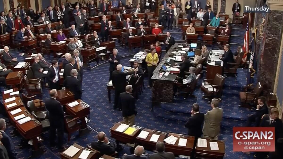 Sen. John McCain on the Senate floor surrounded by desks and colleagues
