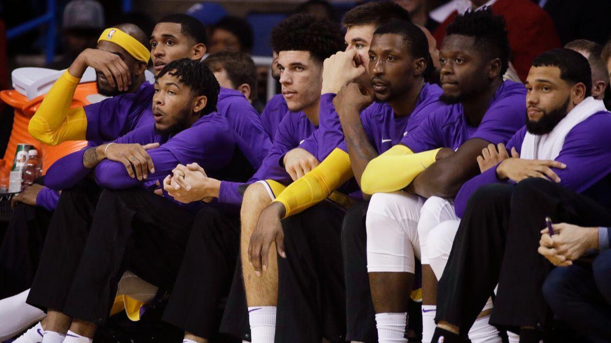 Lakers players watch from the bench during the first half of a preseason game against the Denver Nuggets on Wednesday in Ontario.