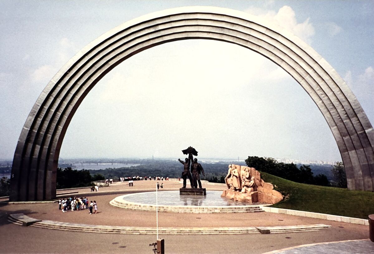A massive arch in Kyiv reaches toward the clouds like a titanium rainbow. Monuments below celebrate Russian-Ukrainian unity.