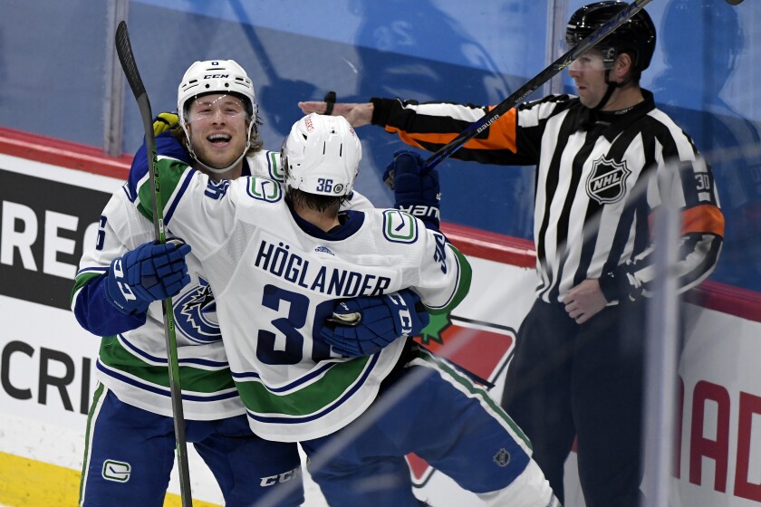 Vancouver Canucks' Nils Hoglander (36) celebrates his goal with teammate Brock Boeser (6) during the third period of an NHL game in Winnipeg, Manitoba, Monday, May 10, 2021. (Fred Greenslade/The Canadian Press via AP)