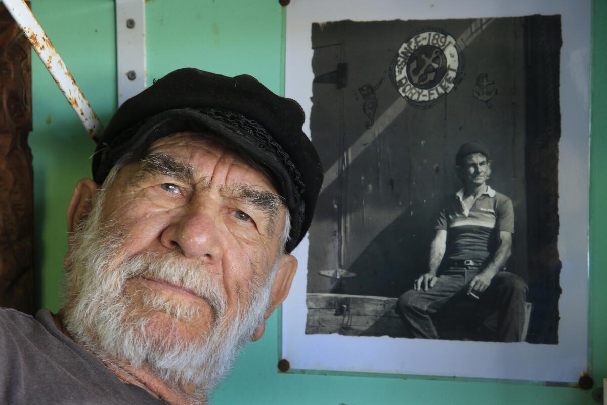 Fishing family patriarch Stratos Voyatzis is shown with a photo of his younger self at the Dory Fleet market.