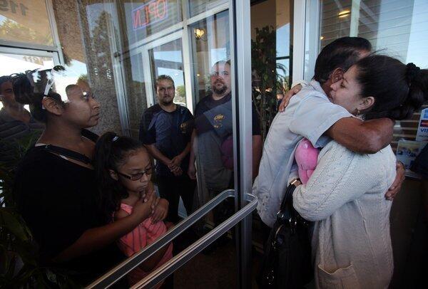 Magdalena Garcia hugs an employee of Chips Restaurant in Hawthorne, where her slain brother Filimon Lamas was a co-owner. A news conference at the restaurant announced a fund that had been set up for relatives of the victims in Saturday's shooting, blamed on a tenant who was being evicted.