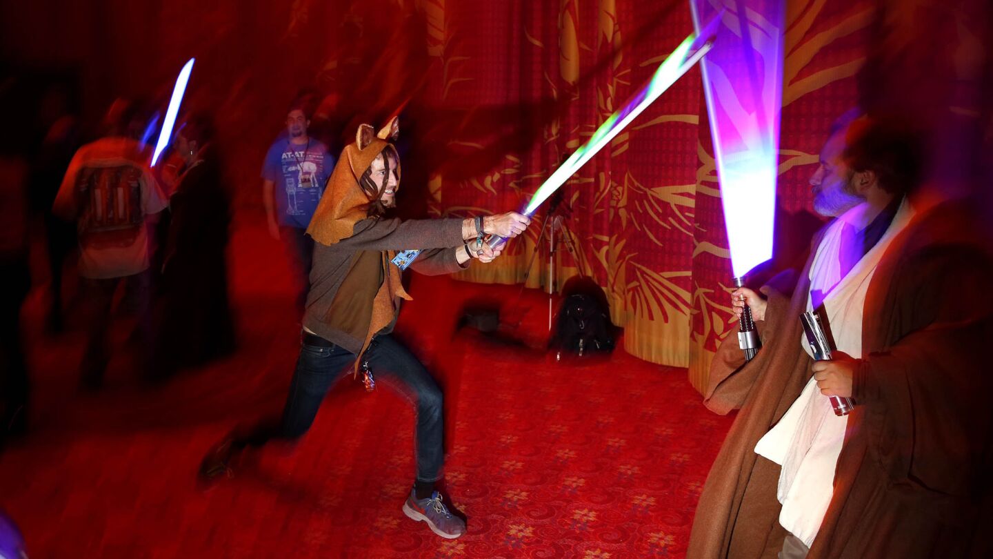 Fans play with lighsabers.