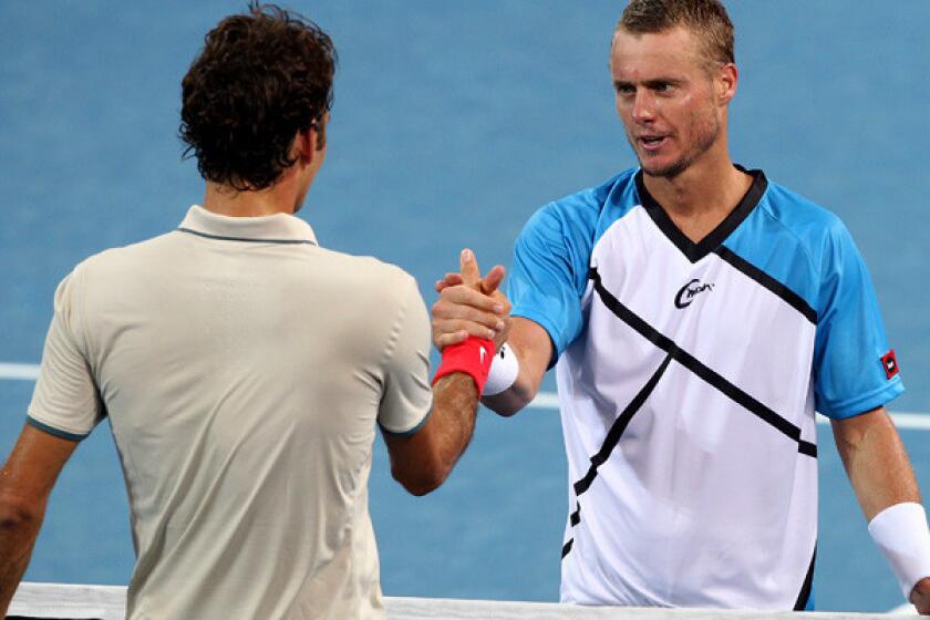 Roger Federer, left, congratulates Lleyton Hewitt after he won the Brisbane International title on Sunday.