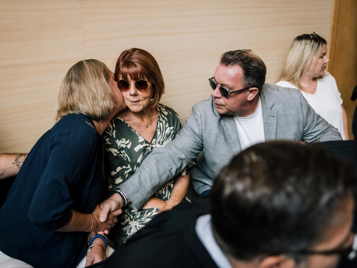 Caroline Darian kisses her mother Gisele Pelicot's cheek in court.