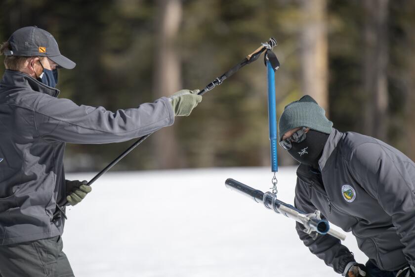 (left to right) Anthony Burdock Engineer, Water Resources in Snow Surveys and Water Supply Forecasting Section, and Sean de Guzman, Chief of the California Department of Water Resources Snow Surveys and Water Supply Forecasting Section, conduct the third media snow survey of the 2021 season at Phillips Station in the Sierra Nevada Mountains. The survey is held approximately 90 miles east of Sacramento off Highway 50 in El Dorado County. Photo taken March 2, 2021. Ken James / California Department of Water Resources, FOR EDITORIAL USE ONLY