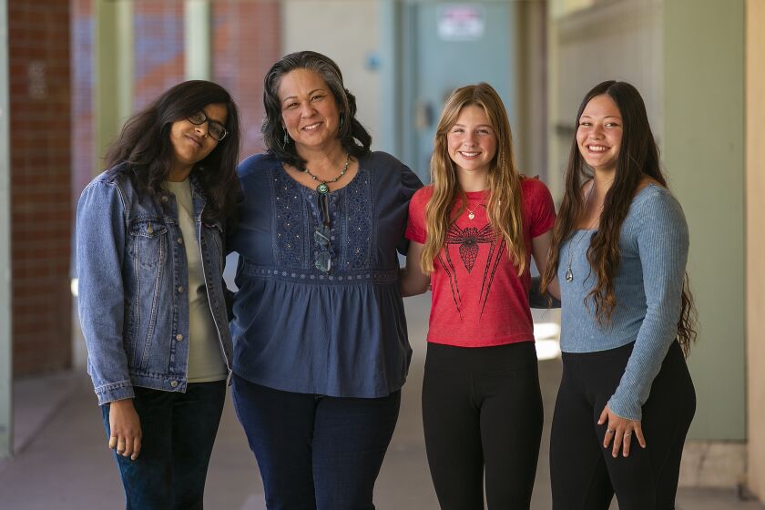 Costa Mesa, CA - March 09: Costa Mesa High School and Middle School art teacher Keli Marchbank, second from the left, with her students Fnu Anu, 17, left, Allie Trask, 14, and Dharma Andreas, 18, right, have taken part in the Memory Project, in which students create a portrait of a child from across the world. Photo taken on Thursday, March 9, 2023 in Costa Mesa, CA. (Scott Smeltzer / Daily Pilot)