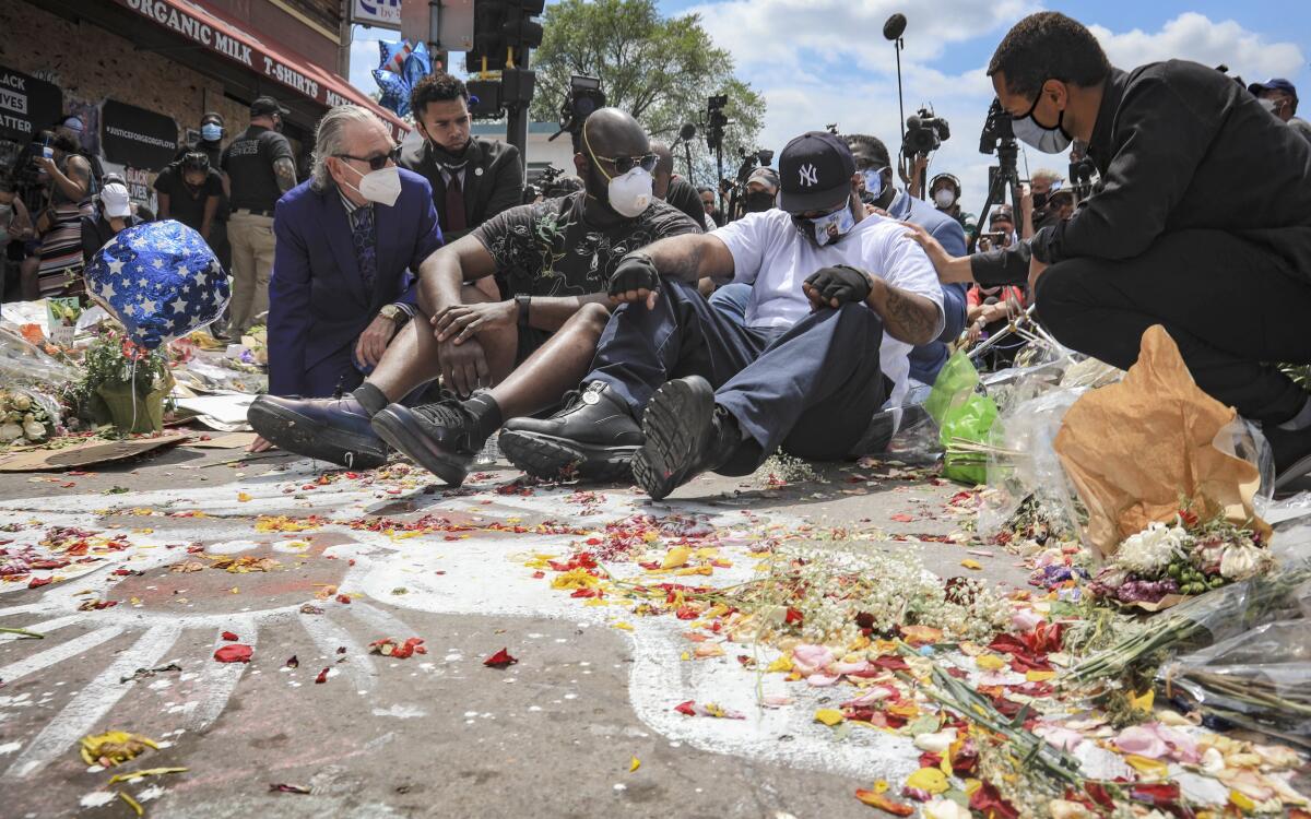 Terrence Floyd, in white, sits where a Minneapolis officer pinned his late brother George to the ground.