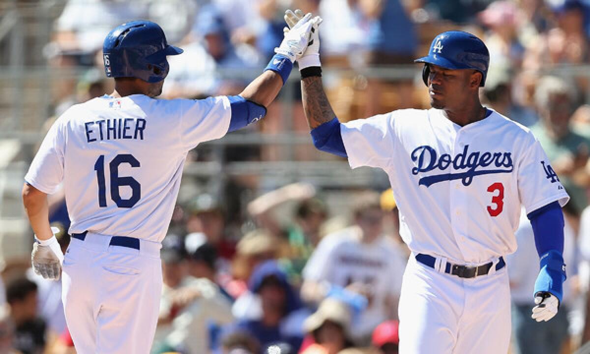Dodgers outfielder Andre Ethier, left, is congratulated by teammate Carl Crawford after hitting a three-run home run in the first inning of the Dodgers' 8-8 exhibition tie against the Oakland Athletics on Monday.