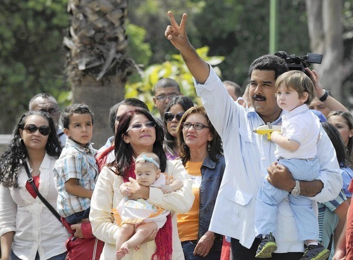 Interim President Nicolas Maduro appears with his grandson outside a polling station in Caracas, Venezuela, before casting his vote. He won by 1.5 percentage points.