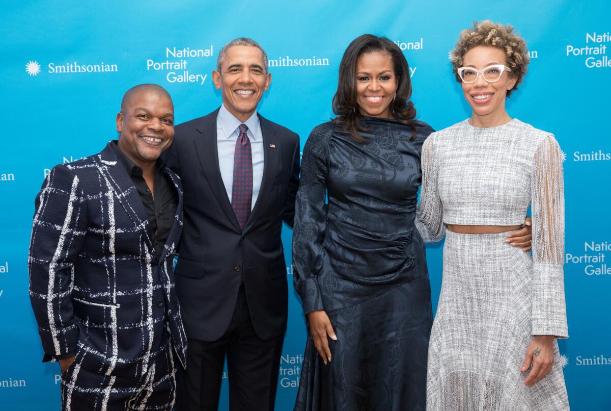 Artist Kehinde Wiley, left, stands next to former President Barack Obama, whose portrait he painted. Amy Sherald, right, painted former First Lady Michelle Obama.