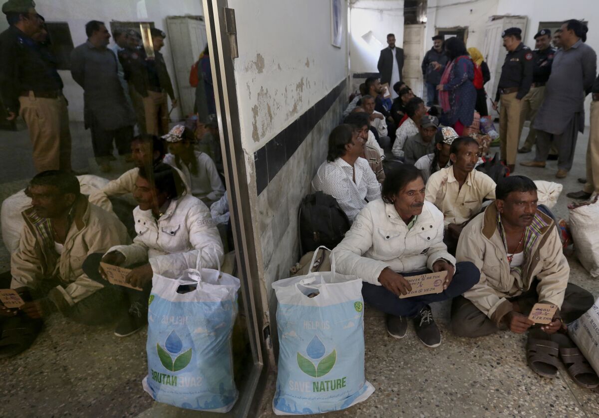 Indian fishermen wait for transport to leave for their homeland following their release from a district jail, in Karachi, Pakistan, Sunday, Nov. 14, 2021. Pakistan freed 20 Indian fishermen who spent four years in prison in the port city of Karachi for violating the country's territorial waters, official said. (AP Photo/Fareed Khan)