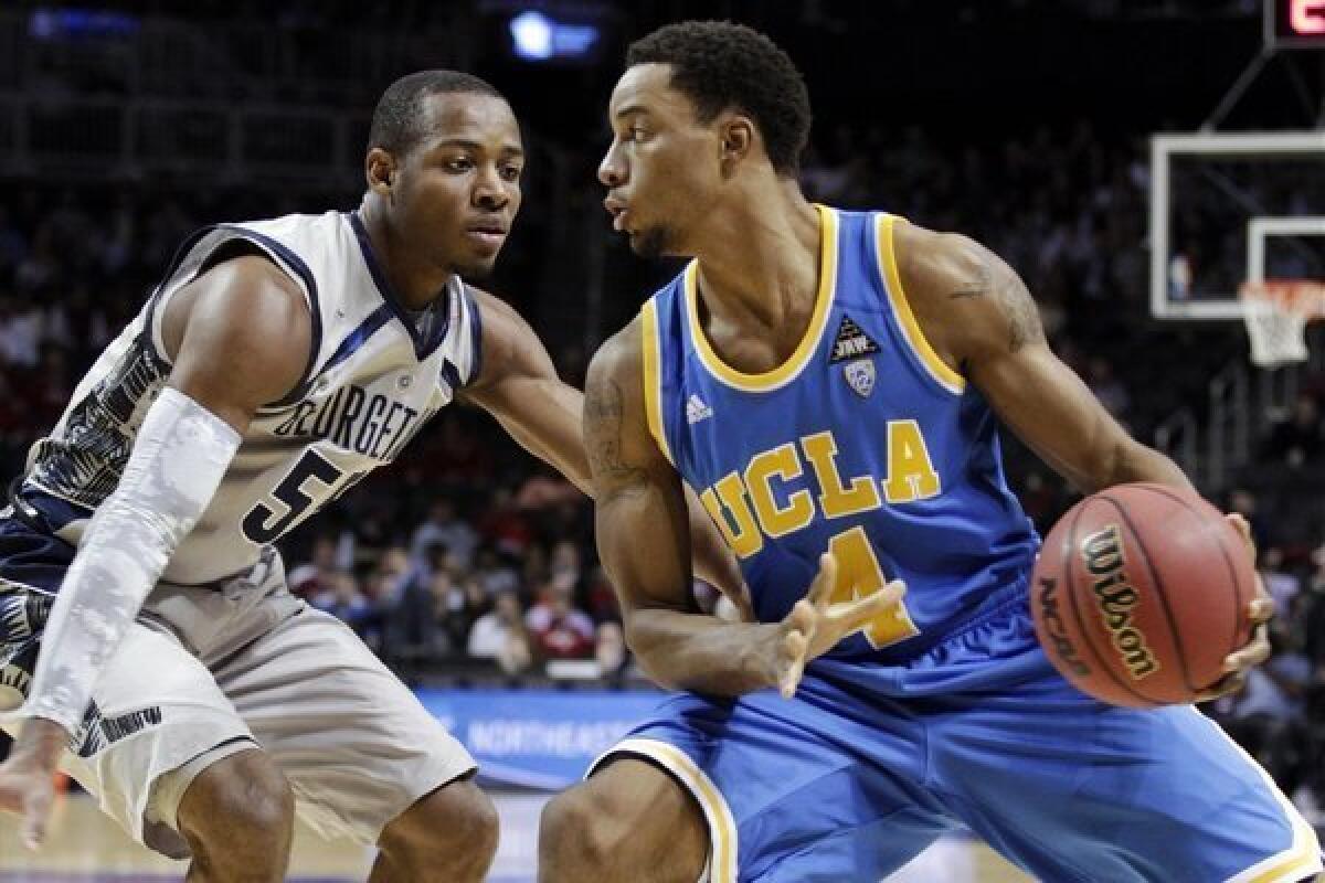 UCLA's Norman Powell protects the ball from Georgetown's Jabril Trawick in the first half of their game on Nov. 19.