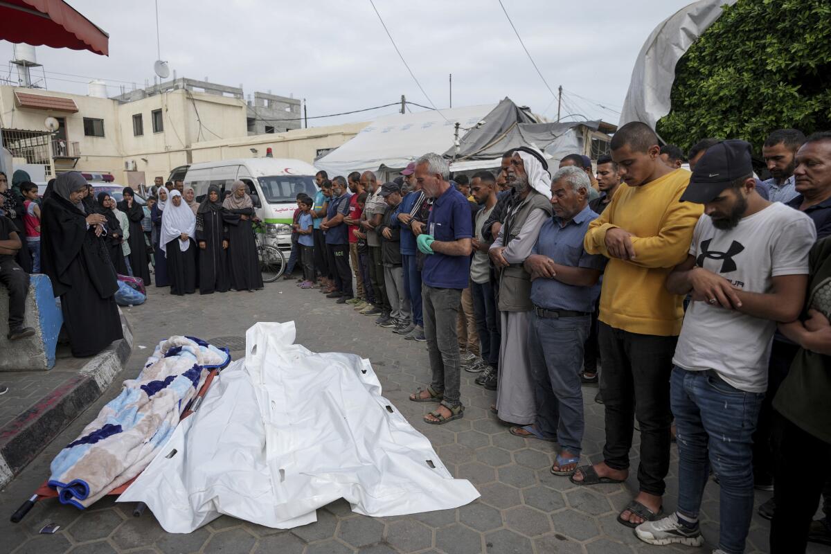 Mourners pray near the bodies of Palestinians who were killed in an Israeli airstrike in the Gaza Strip.