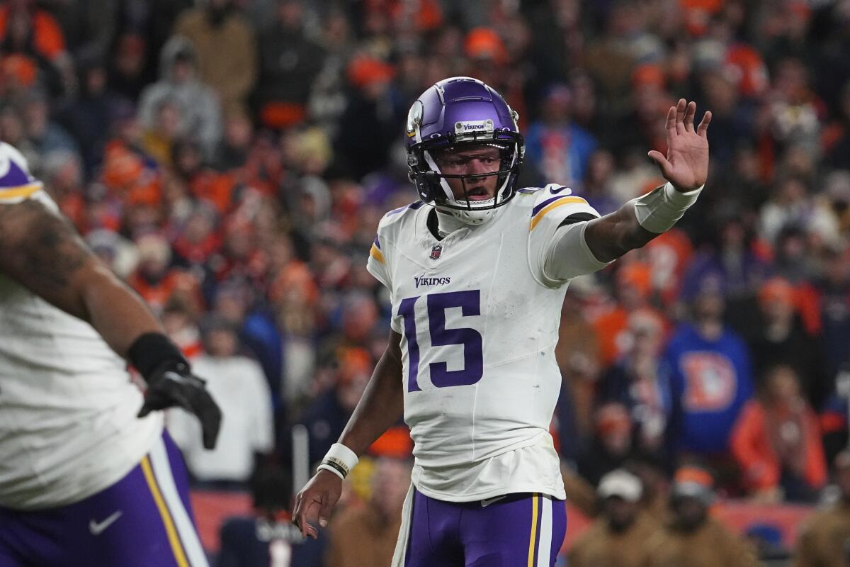 Minnesota Vikings quarterback Joshua Dobbs (15) signals teammates.