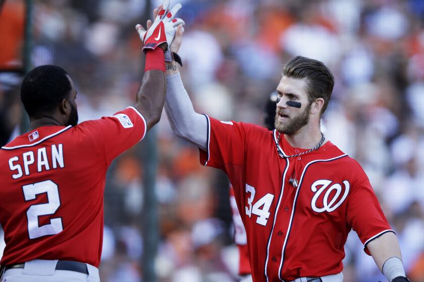 Washington Nationals teammates Denard Span, left, and Bryce Harper celebrate after scoring on a throwing error during the seventh inning of a 4-1 win over the San Francisco Giants in Game 3 of the National League division series Monday.