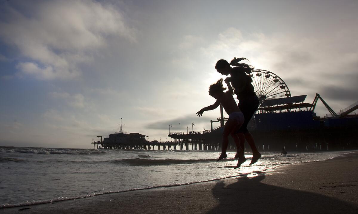 Young people play in the surf south of the Santa Monica Pier. The beach was named No. 7 most-polluted in California in an analysis of 2013 water quality readings by the environmental group Heal the Bay.