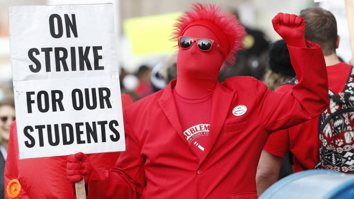 An teacher holds a placard during a march to Denver Public Schools headquarters to deliver Valentine’s Day cards Wednesday.