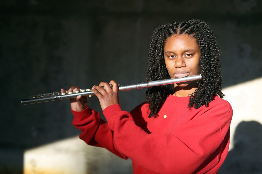 A teenager prepares to play her flute.
